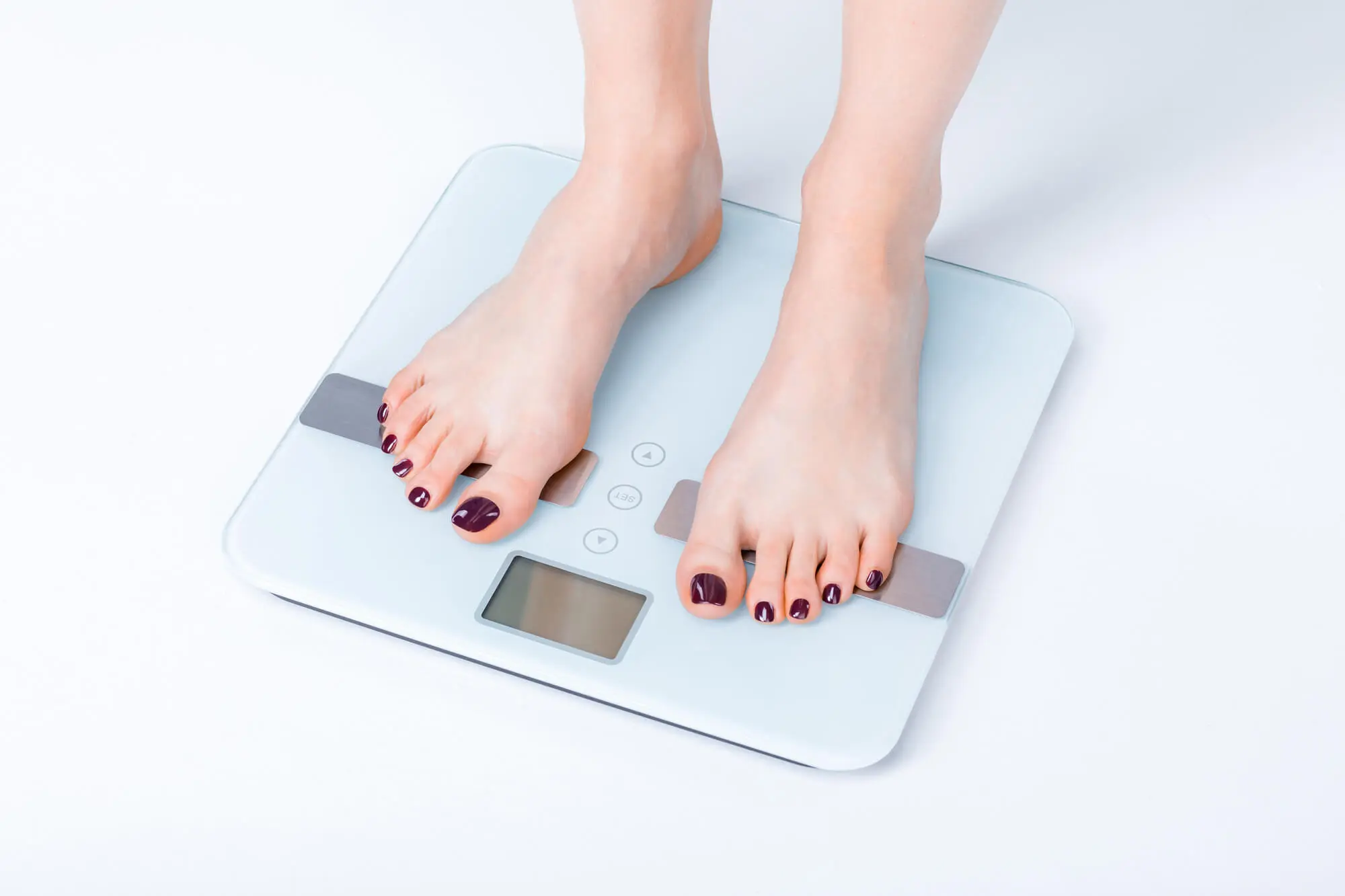 woman checking her weight to keep track of her weight loss journey in 33410